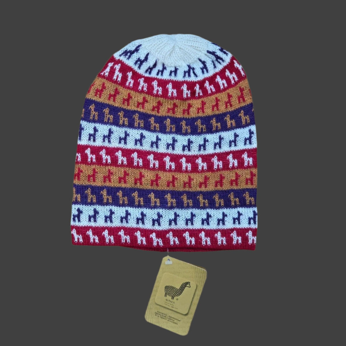 A multicolor knit beanie hat with horizontal stripes of Alpaca silhouettes in navy, red, tan, and light blue, shown with a tan paper tag below on a white background.