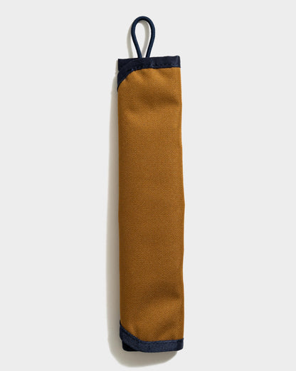The Straw Kit in Camel from United By Blue displayed on a white background rolled up.