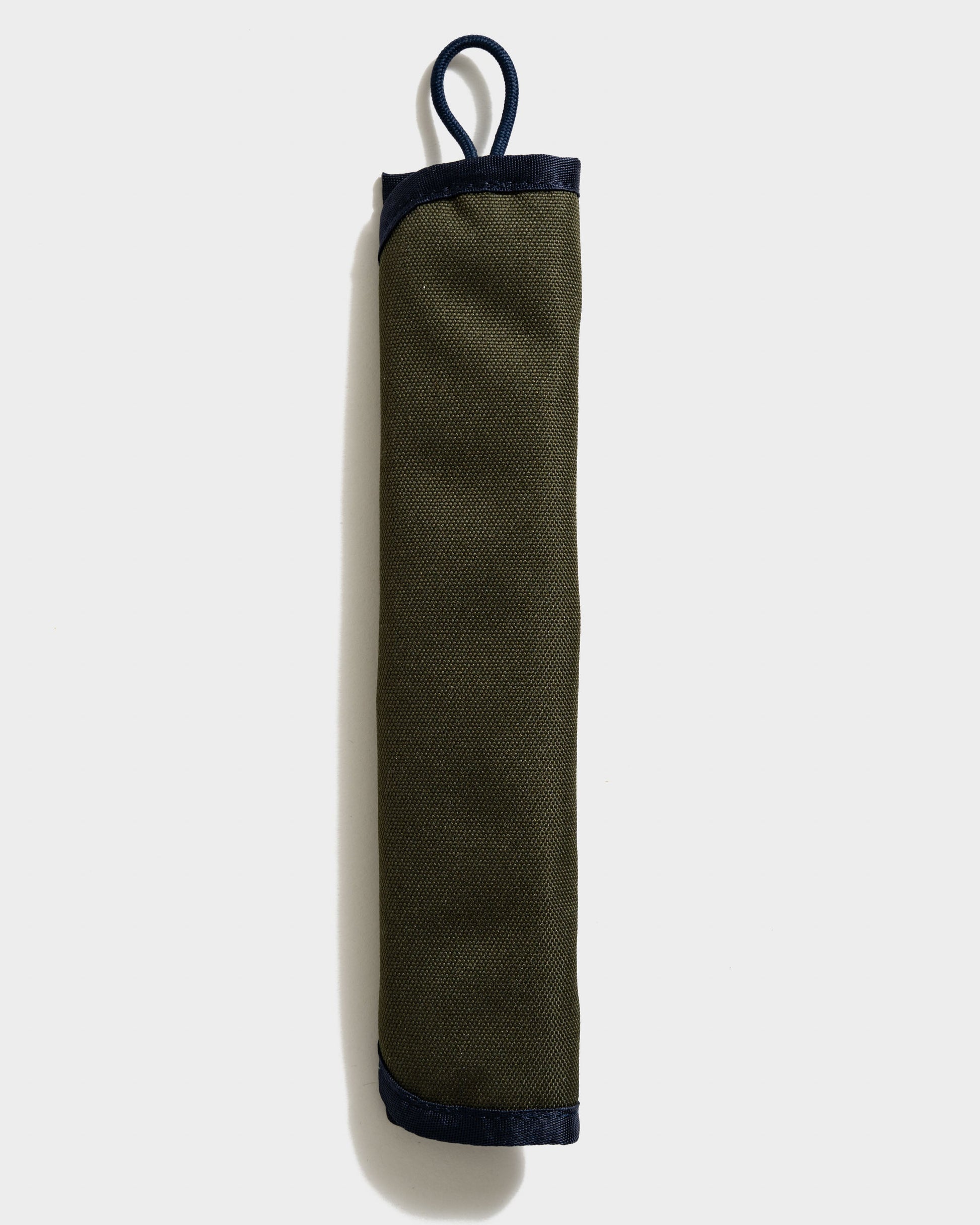 The Straw Kit in Olive from United By Blue displayed rolled up on a white background.