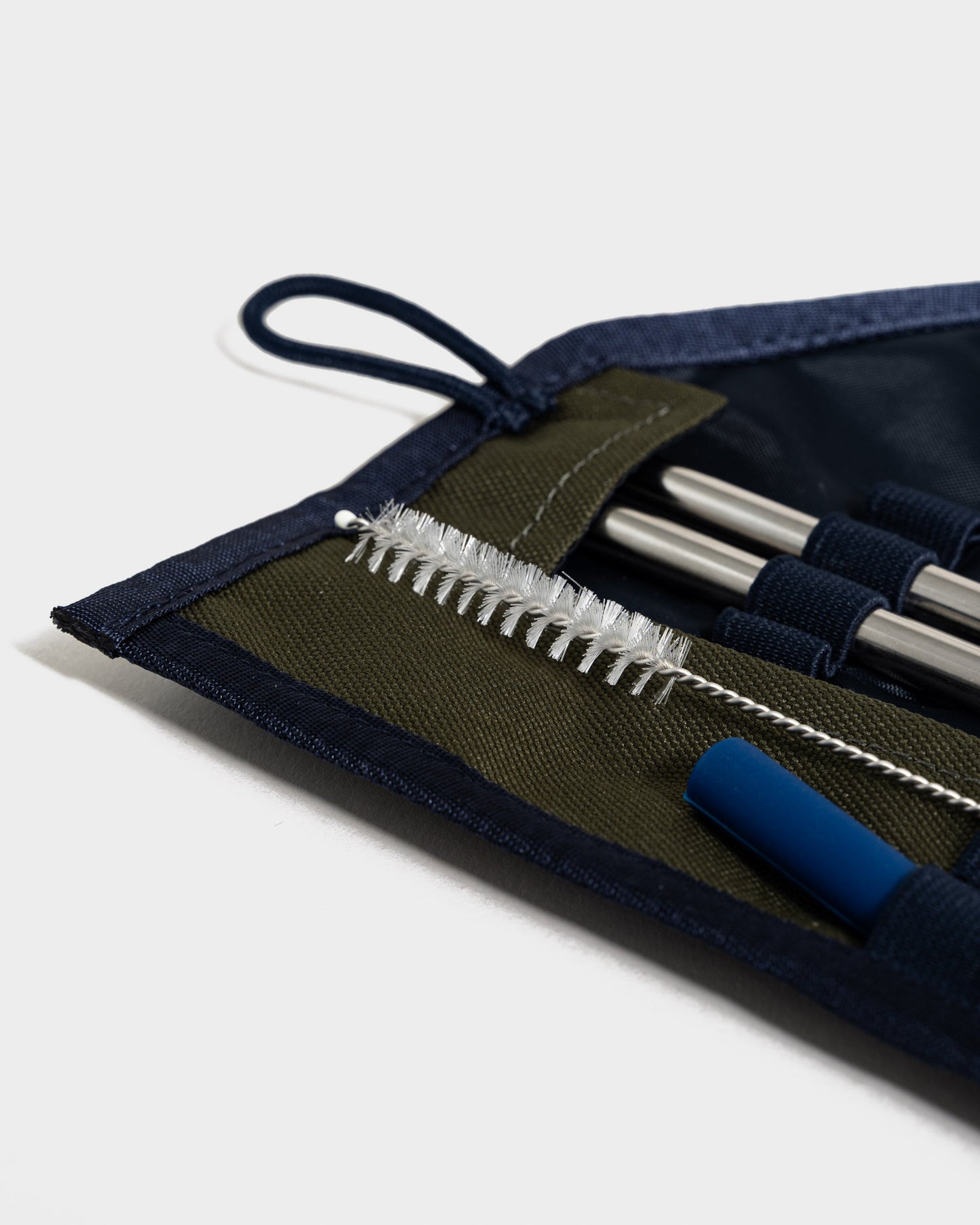 The Straw Kit Olive from United By Blue displayed open on a white background close up.