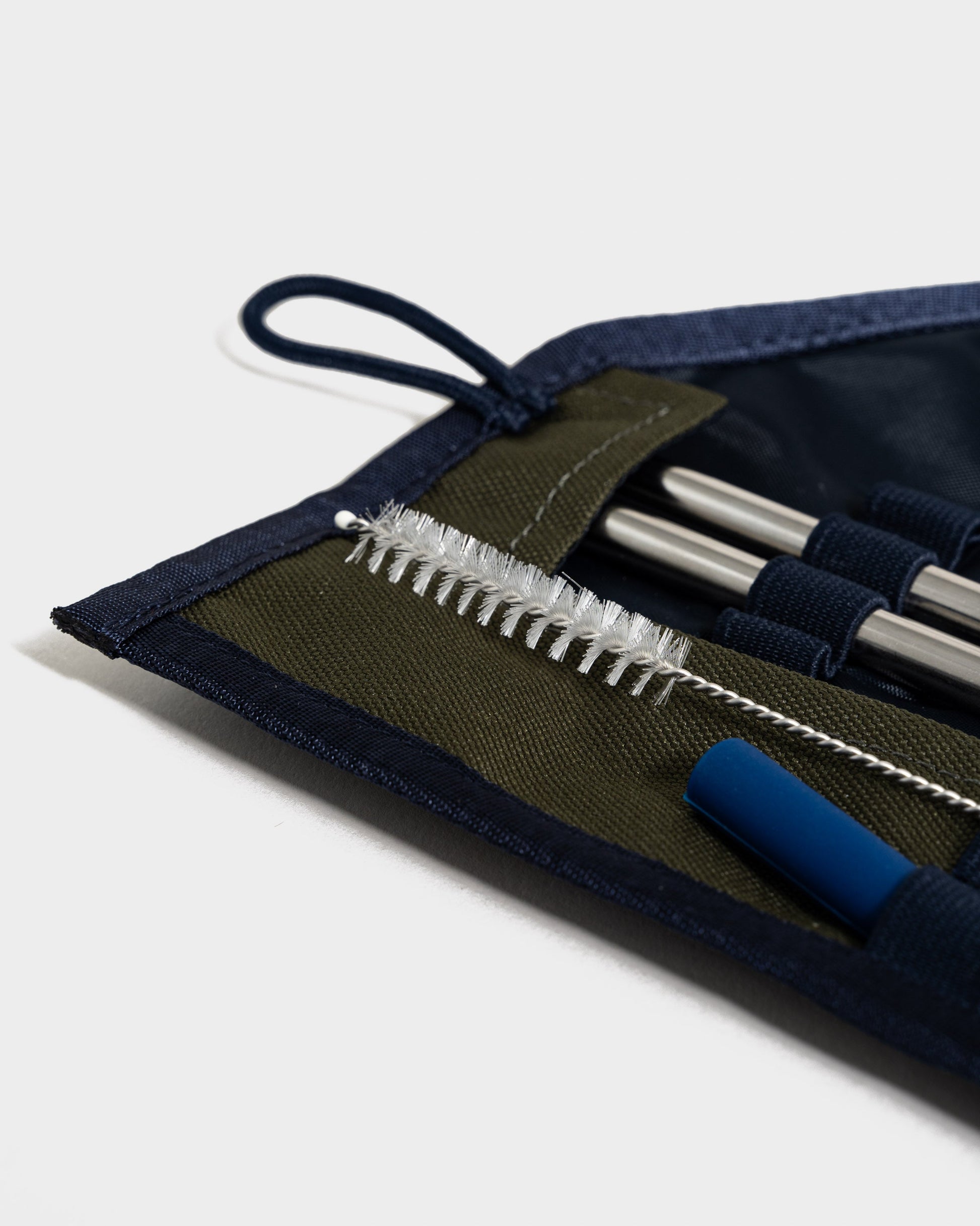 The Straw Kit Olive from United By Blue displayed open on a white background close up.