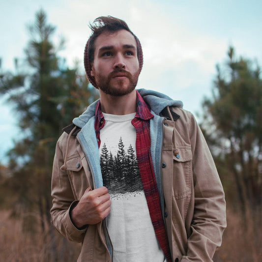 Male in the woods wearing The Timber Line 100 percent cotton Unisex T-Shirt by Kempain, ice grey, available in sizes Small through 5XL.
