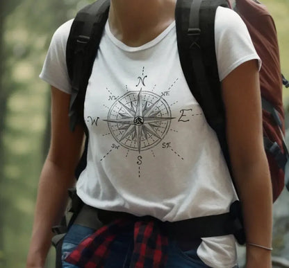 Female hiker wearing The True North Compass 100 percent cotton Unisex T-Shirt by Kempain, white, available in sizes Small through 5XL.