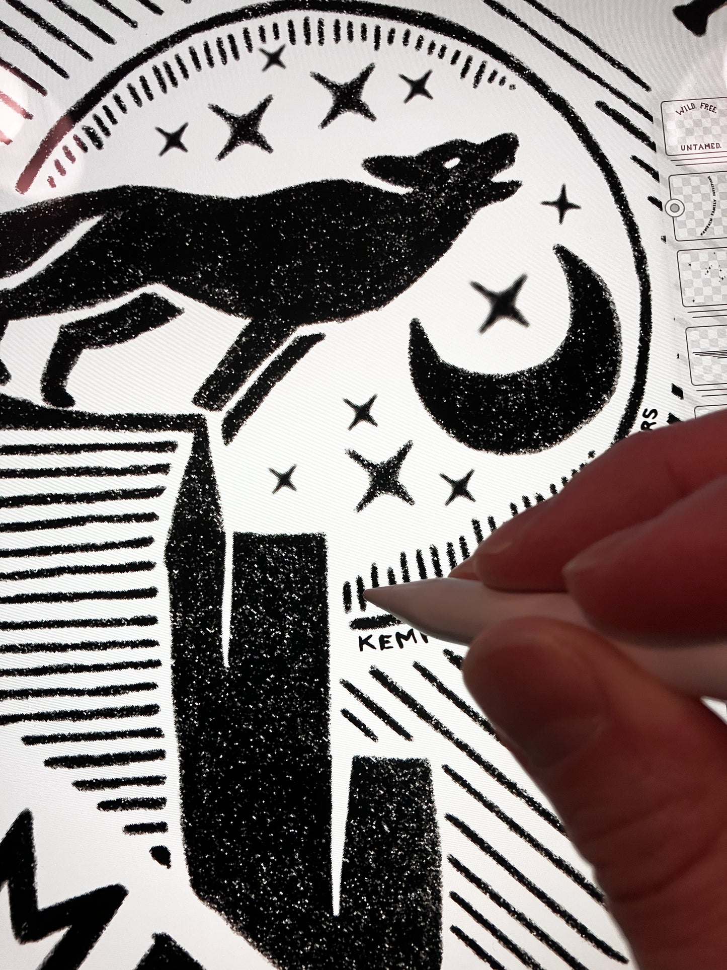 Close up of Jordan Kempain's hand drawing the wolf artwork, showing his process and the line detail and texture of the design.