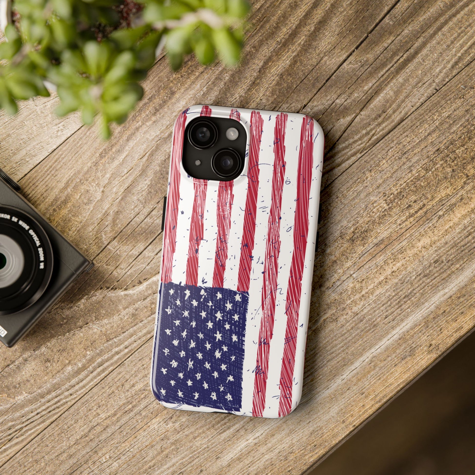 Illustrated American flag design on an iPhone and Samsung phone case, placed on a table, showcasing its sleek and patriotic style for everyday use.