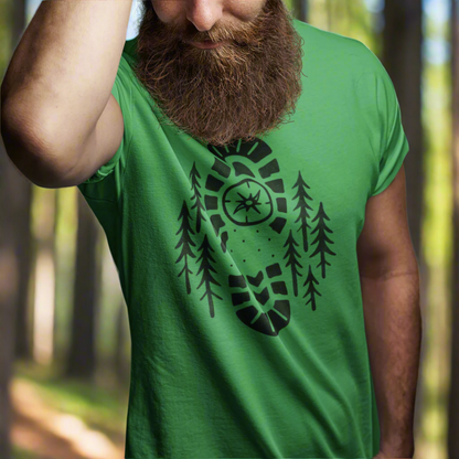 Boot Print Compass Forest T-Shirt worn by model in a pine forest setting, showcasing rugged hiking design for nature lovers.