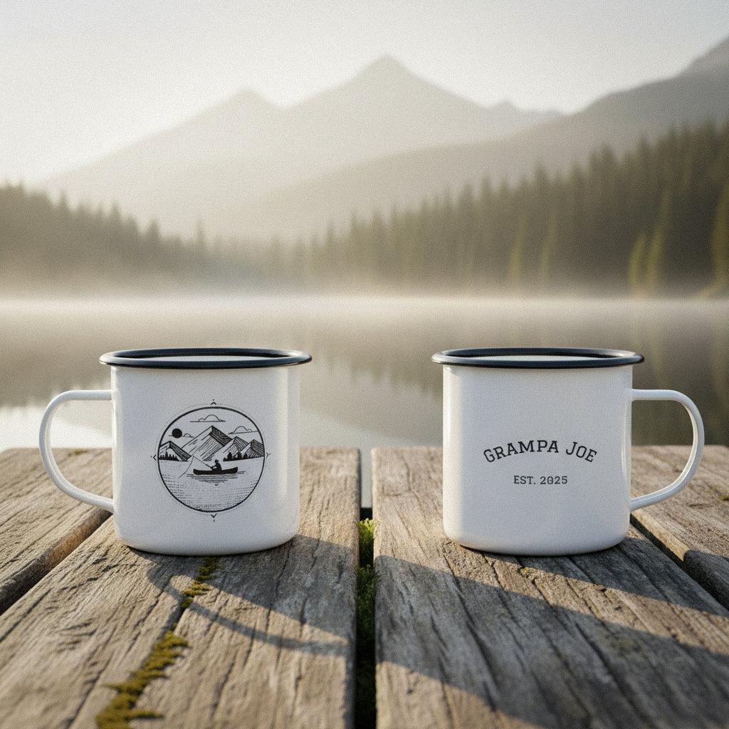 Two custom canoe fishing camp mugs on a rustic wooden dock by a misty lake at mid-morning.
