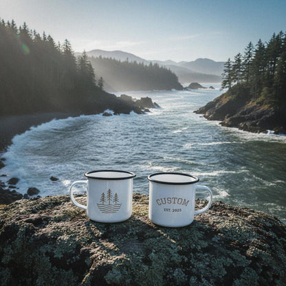 Two personalized waves and timber line mugs on a rocky point overlooking a choppy coastal bay with pine trees.