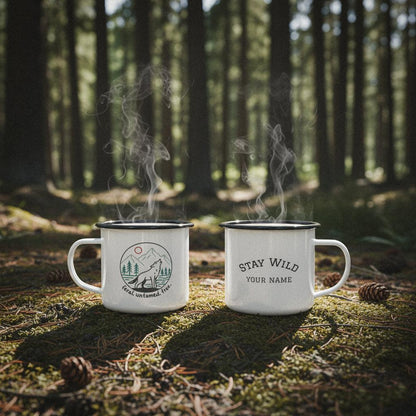 Two personalized wolf howling camp mugs on a mossy forest floor with pinecones and sunlight.