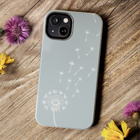 Dandelion Phone Case with a delicate drifting dandelion seed design, shown on a rustic wood desk for a nature-inspired aesthetic.