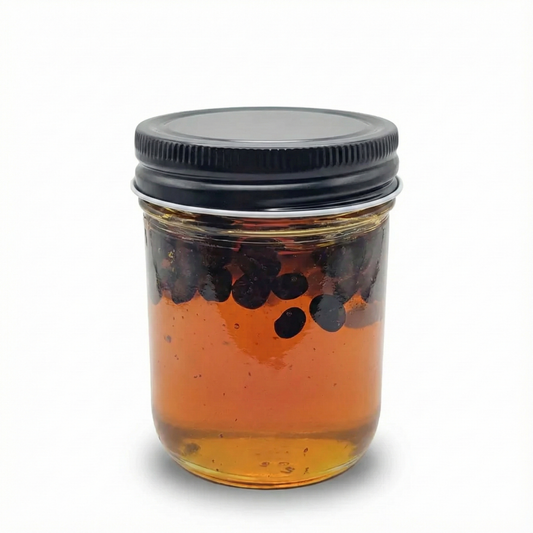 Jar of honey with artisan infused coffee beans on a white background