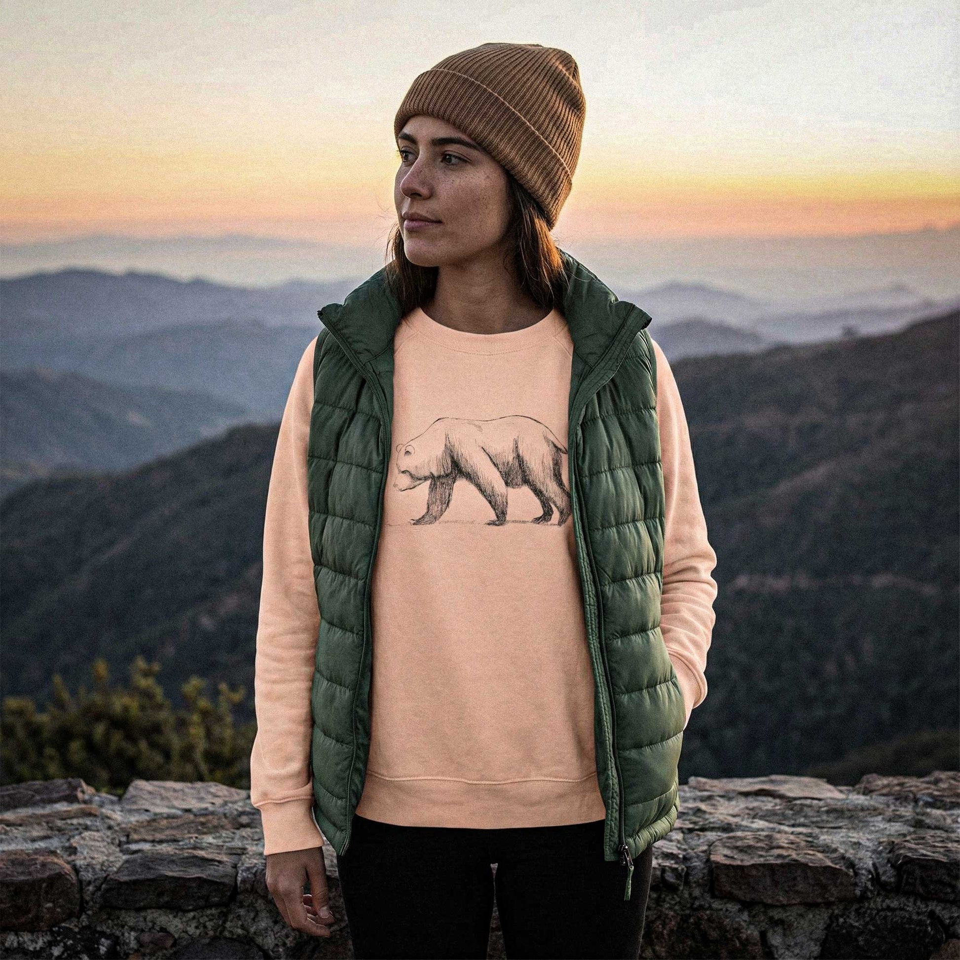 Lifestyle view of the Grizzly Study sweatshirt at a mountain summit, showcasing the breathable 6.4 oz field-blank designed for the trail.