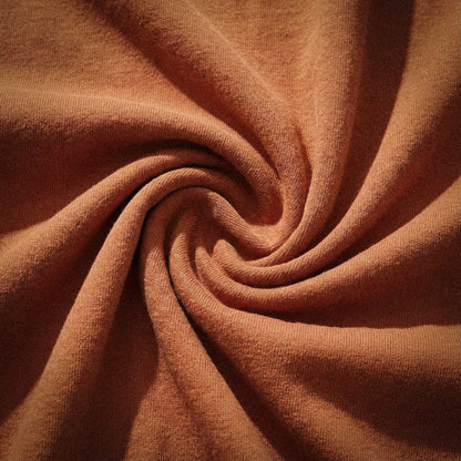 Macro detail of 100% ring-spun US cotton fabric in terracotta (Yam), showcasing the 6.4 oz field weight and breathable natural fiber texture of the Artist Series Comfort Colors 1466 with zero synthetic blends.