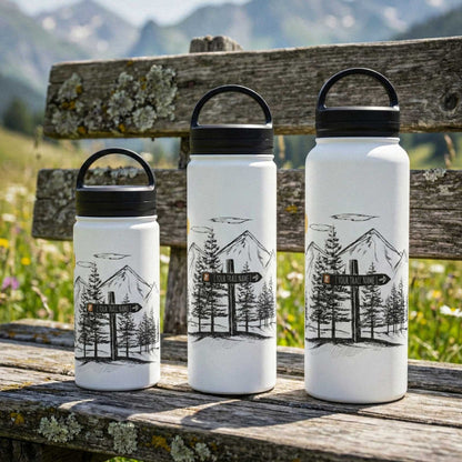 A collection of 12oz, 18oz, and 32oz custom mountain-etched water bottles arranged on a mountain bench, showing the size range for family hiking trips.