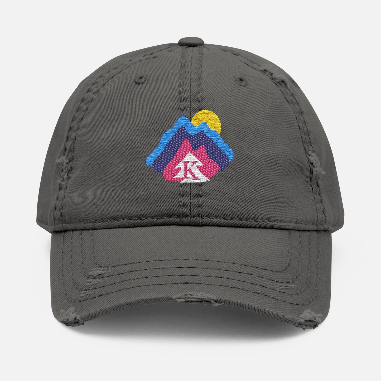  Front view of grey distressed dad hat on white background, featuring an embroidered mountain and sun design with the Kempain Family Outfitters tree + K emblem.
