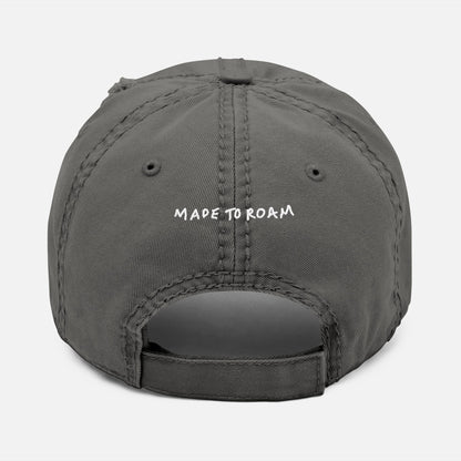 Back view of grey distressed dad hat on white background with “Made to Roam” embroidered in hand-drawn script.