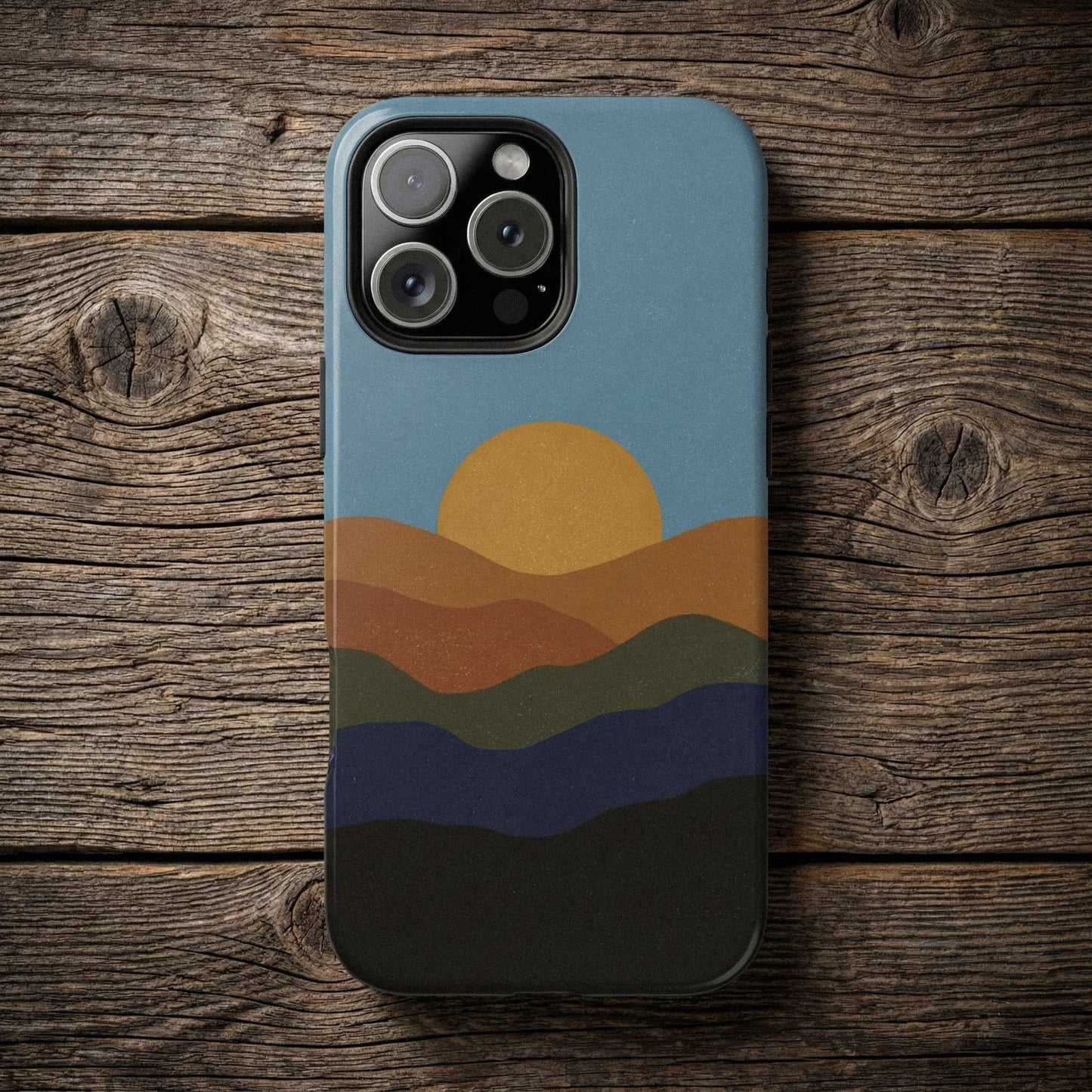 Phone case with sunset design on a wooden surface