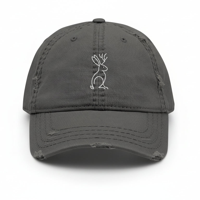 Front view of charcoal grey Mythborn Jackalope Dad Hat with Picasso-inspired line art of a jackalope, shown on white background.