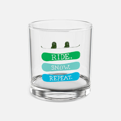 Rocks glass with the phrase 'Ride, Snow, Repeat' and a snowboarding-themed design, displayed on a clean white background, ideal for showcasing stylish drinkware.