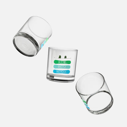 Set of three rocks glasses with the phrase 'Ride, Snow, Repeat' and a snowboarding-themed design, floating on a white background and shown from multiple angles.