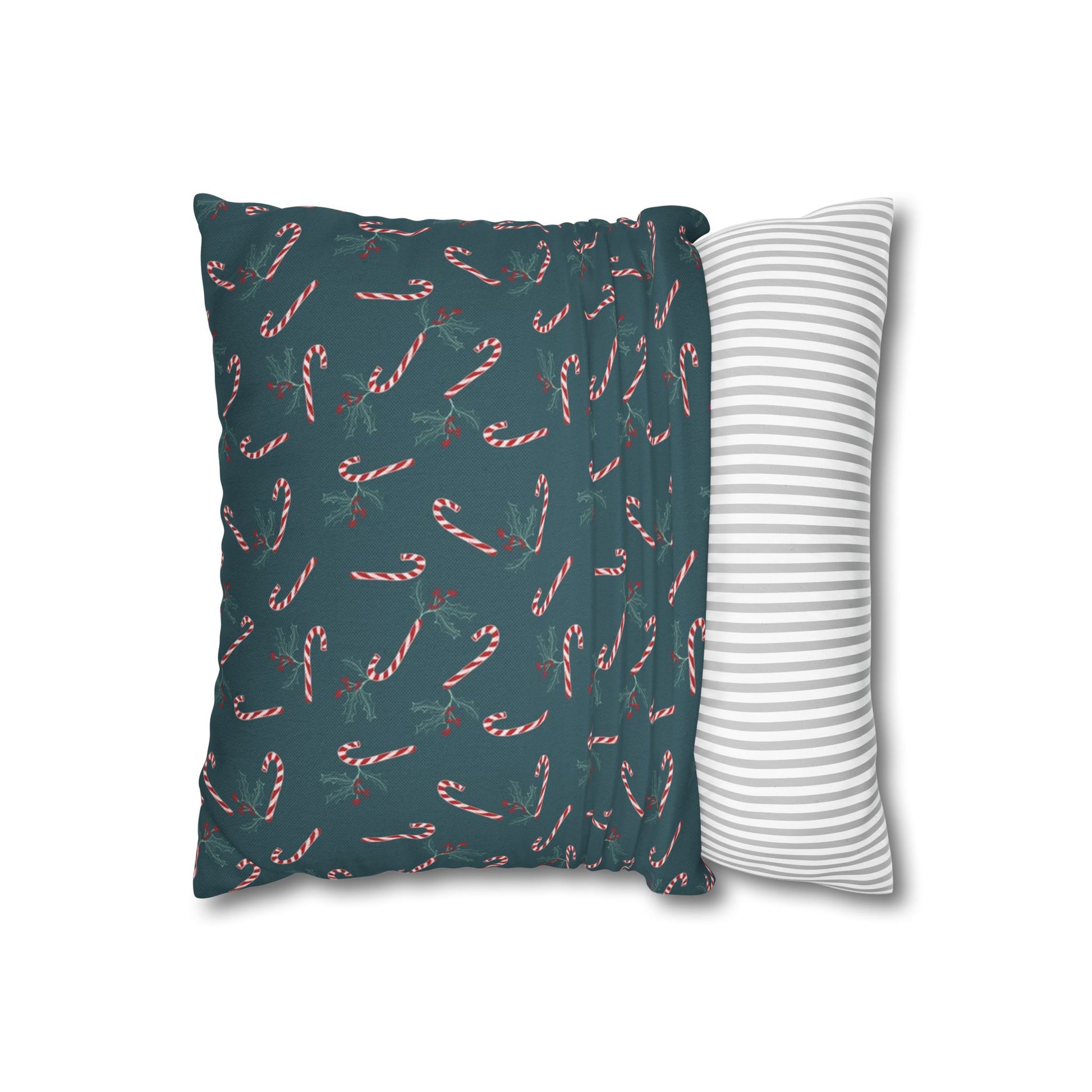 Square pillow case with a candy cane and holly pattern, partially pulled over a throw pillow, showing how it fits and highlighting the festive holiday design.
