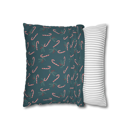 Square pillow case with a candy cane and holly pattern, partially pulled over a throw pillow, showing how it fits and highlighting the festive holiday design.