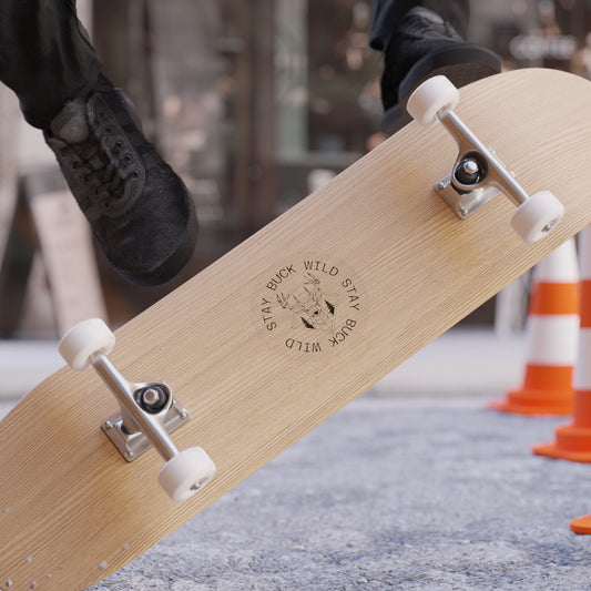 Skateboard with a visible stay buck wild sticker on a blurred background