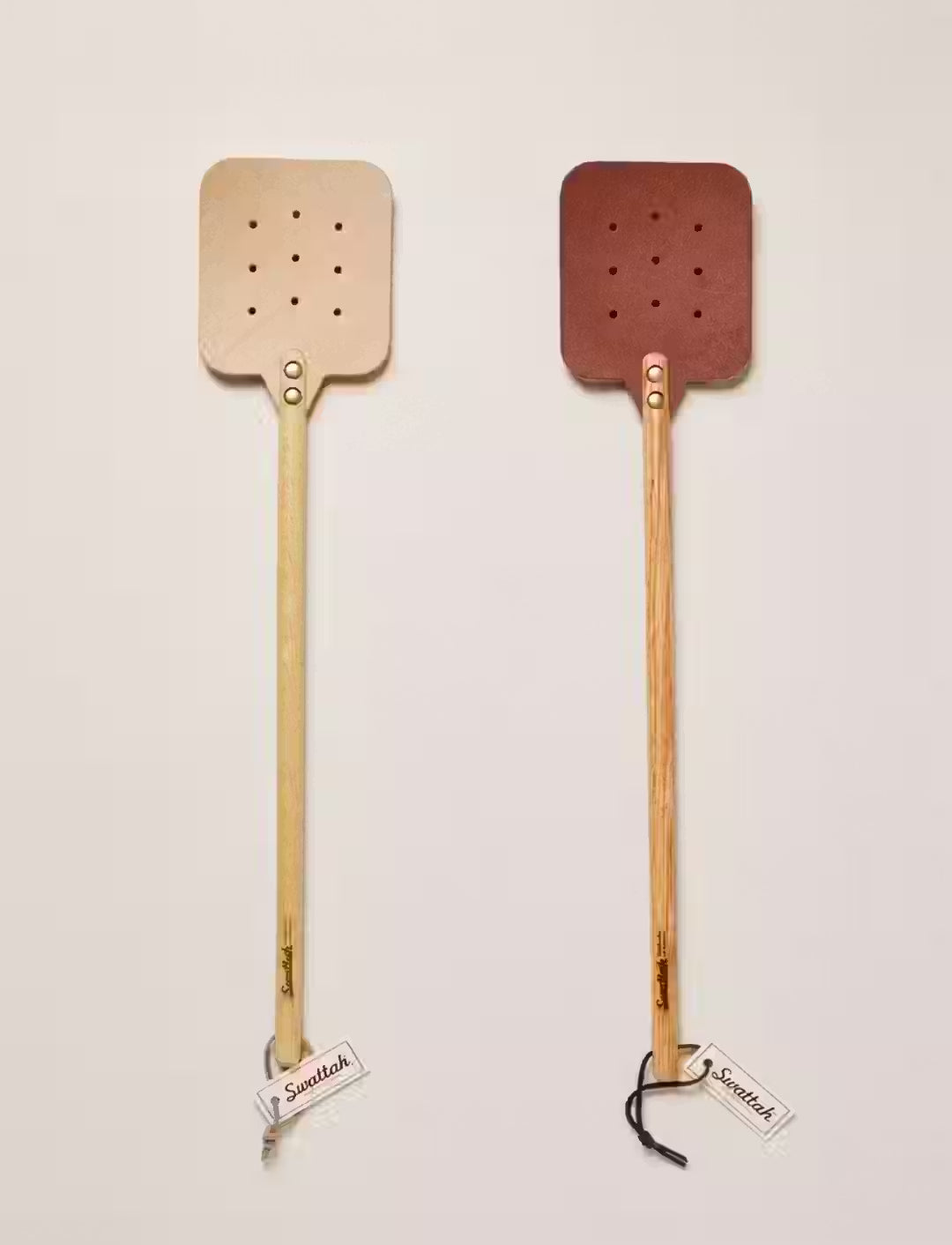 Two Leather Huntsman Flyswatters  by Farmhouse Pottery sold by Kempain Family Outfitters featuring both leather color options featured on a solid gray background.