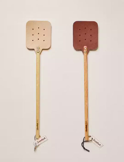 Two Leather Huntsman Flyswatters  by Farmhouse Pottery sold by Kempain Family Outfitters featuring both leather color options featured on a solid gray background.