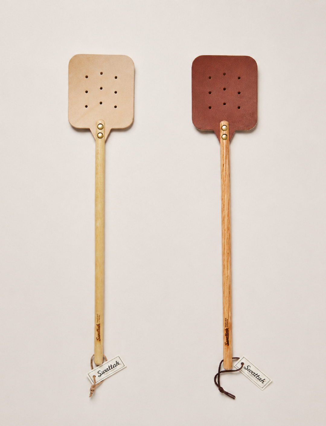 Two Leather Huntsman Flyswatters  by Farmhouse Pottery sold by Kempain Family Outfitters featuring both leather color options featured on a solid gray background.