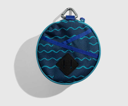 The Navy Meal Kit from United By Blue displayed on a white background closed showing the wave pattern and blue case fabric.