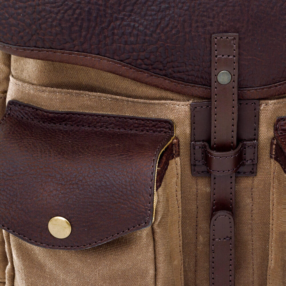 Close up of leather and hardware on The Waxed Canvas Backpack in Smoke-Brown by Mission Mercantile Leather Goods.