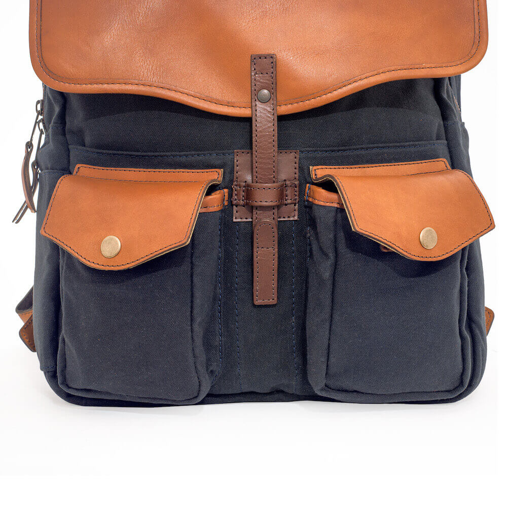 Close up of front hardware and storage pockets on The Waxed Canvas Backpack in hickory-navy by Mission Mercantile Leather Goods.