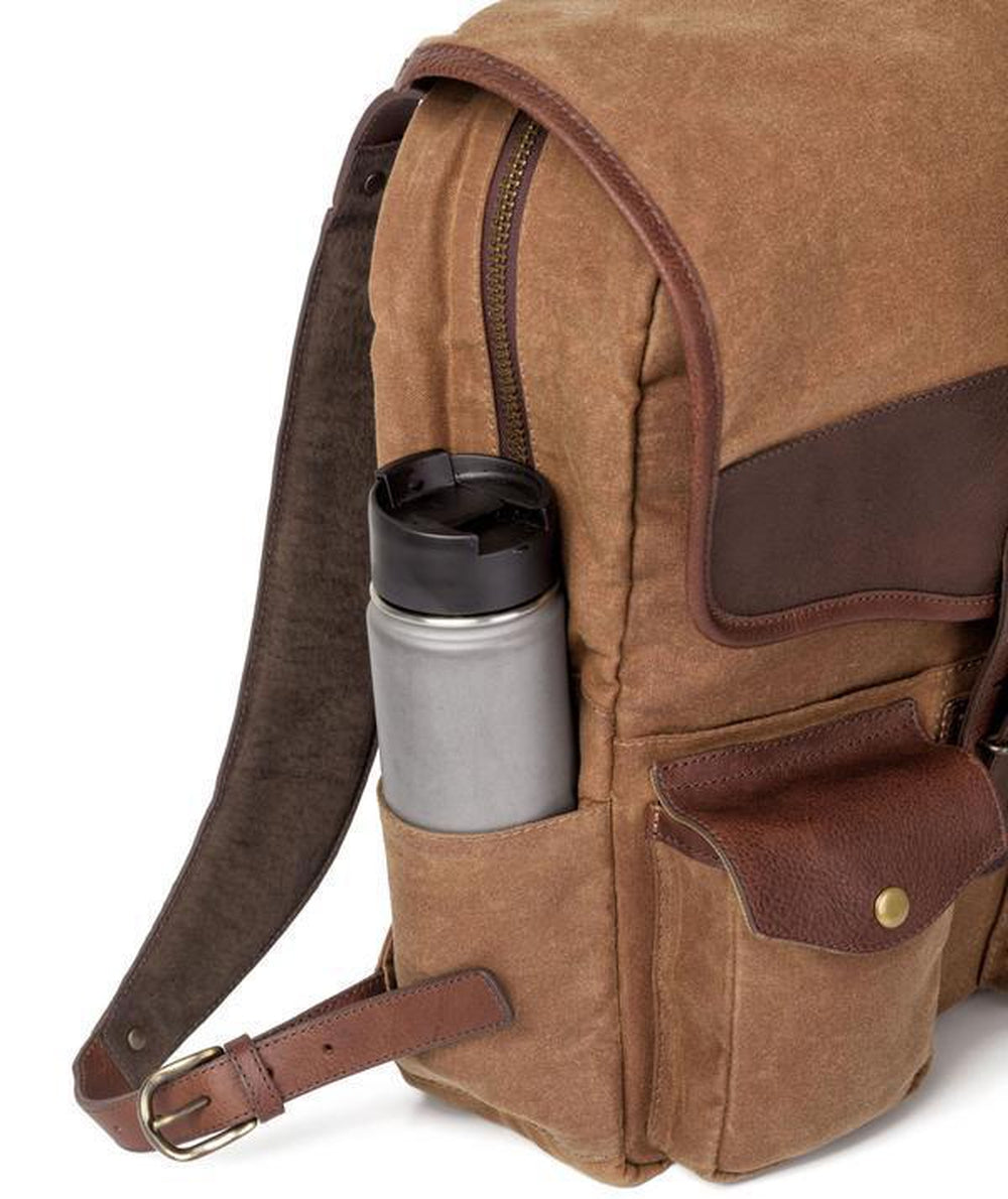 Close up of the bottle holding compartment on The Waxed Canvas Backpack in Smoke-Brown by Mission Mercantile Leather Goods displayed on a white background.