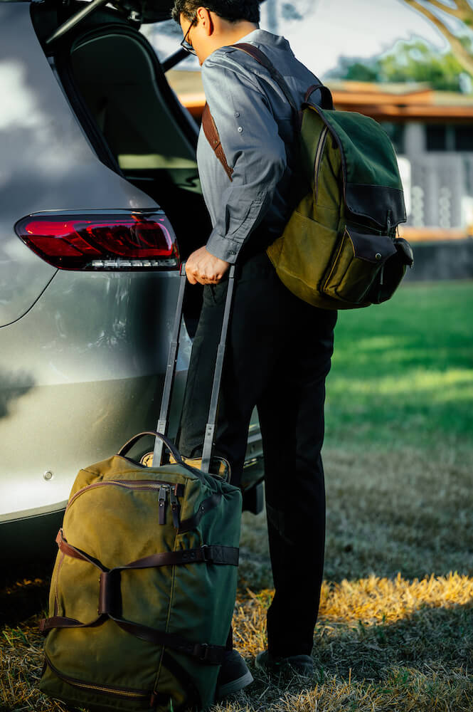 Man wearing The Waxed Canvas Backpack in smoke-forest by Mission Mercantile Leather Goods.