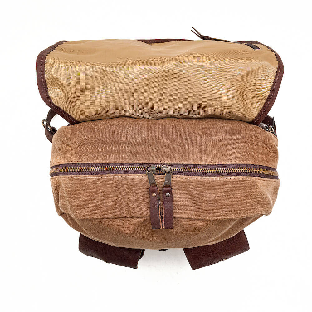 Top view of The Waxed Canvas Backpack in Smoke-Brown by Mission Mercantile Leather Goods on a white background.