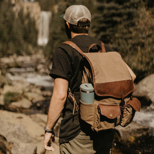Model wearing The Waxed Canvas Backpack in Smoke-Brown by Mission Mercantile Leather Goods.