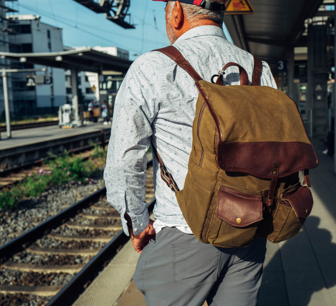 Man wearing The Waxed Canvas Backpack in Smoke-Forest by Mission Mercantile Leather Goods.