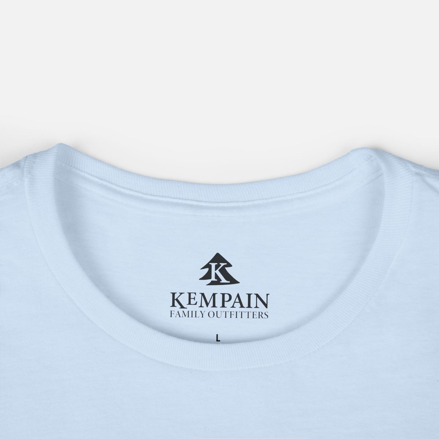 Women's light blue Wildflower Breeze T-Shirt displayed on a white background close up on the crew neck collar and showcasing the Kempain Family Outfitters logo label.