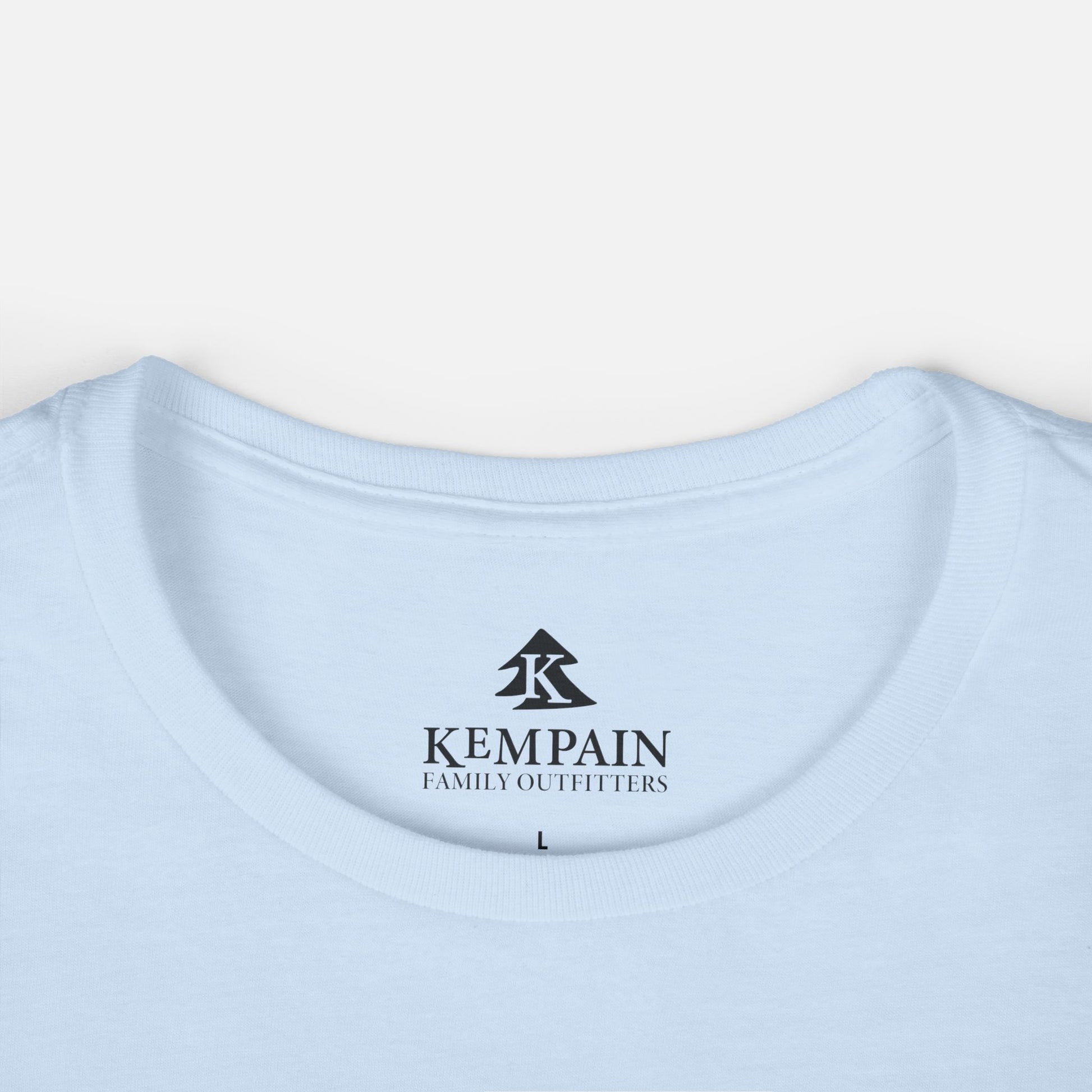 Women's light blue Wildflower Breeze T-Shirt displayed on a white background close up on the crew neck collar and showcasing the Kempain Family Outfitters logo label.