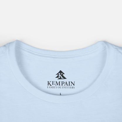 Women's light blue Wildflower Breeze T-Shirt displayed on a white background close up on the crew neck collar and showcasing the Kempain Family Outfitters logo label.
